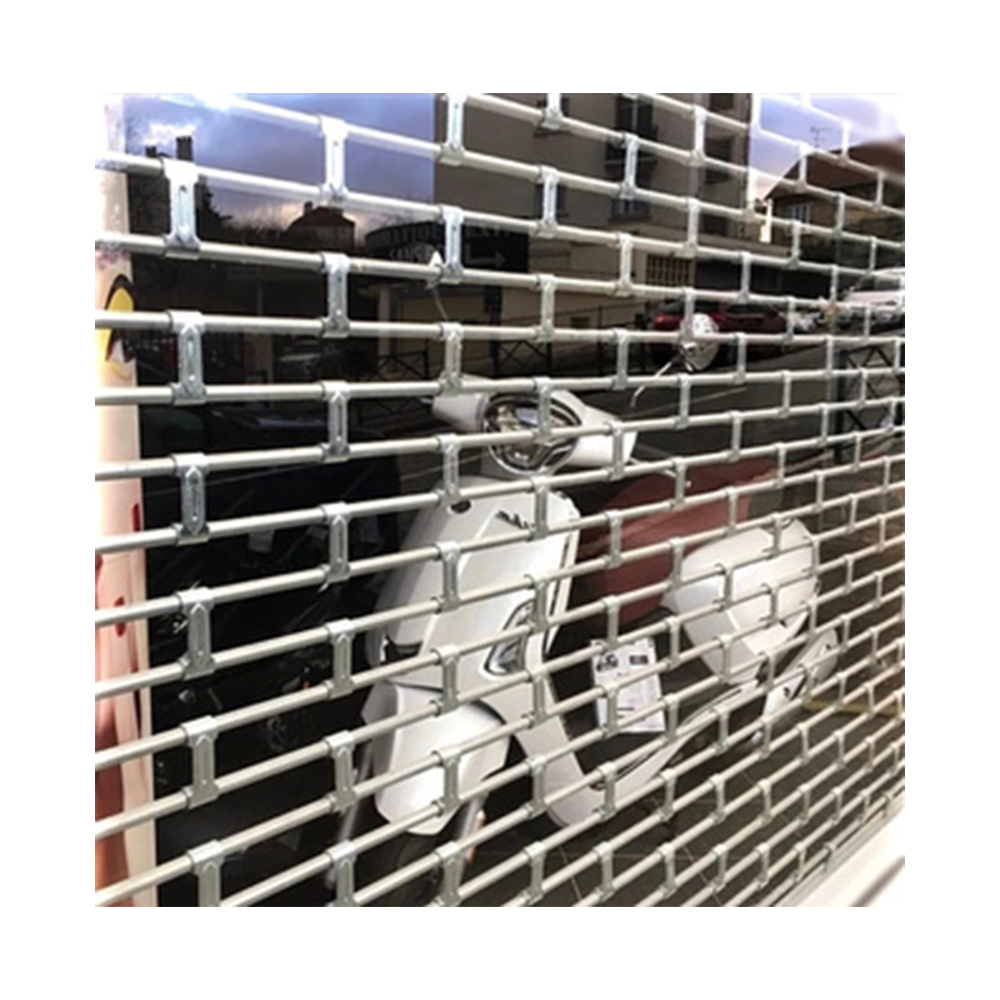 Grille métallique à enroulement de type biellettes P58 protégeant une vitrine d'un commerce à la Réunion. 974